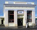 A white building featuring a sign that reads Town Hall prominently displayed on its facade